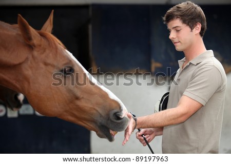 Young man cuddling a horse