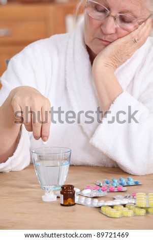 An old lady taking pills.