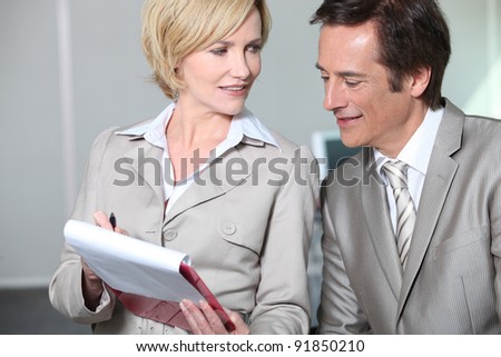 Business colleagues looking at clipboard.