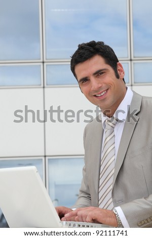 Businessman sat outside modern office block