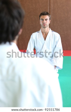Two men kneeling on a judo mat