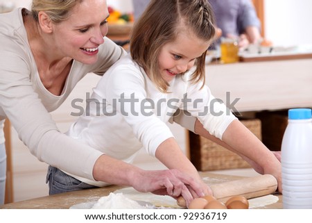 A mother teaching her daughter how to bake.