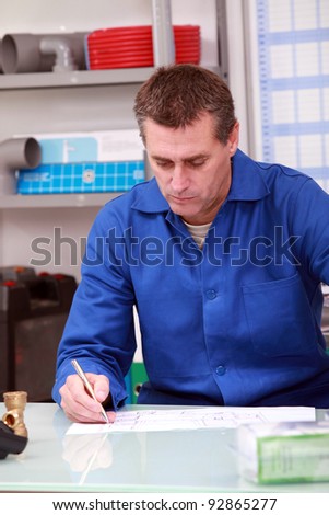 Man in a plumber\'s merchants with paperwork