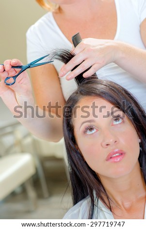 Lady having hair trimmer, looking up nervously