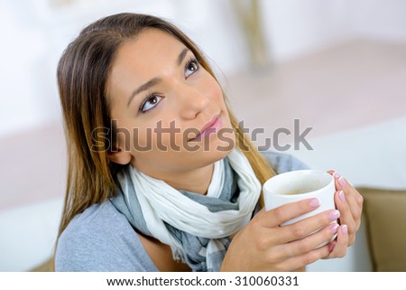 Pensive woman with a mug of coffee