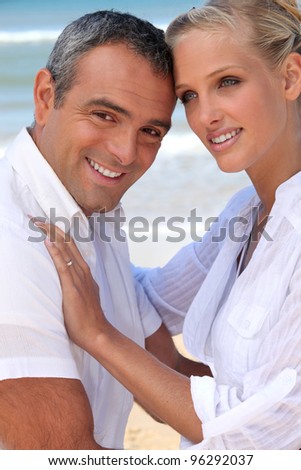 a couple behind the sea : a muscular 40 years old man and a 35 years old blonde woman