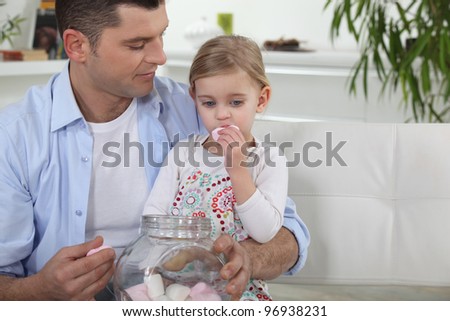 Dad and his daughter eating marshmallows