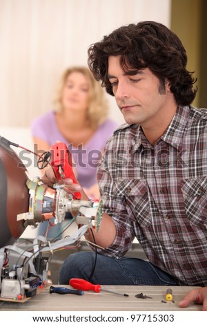 Man repairing television set
