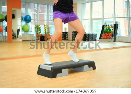 Beautifull female legs on the step board during exercise