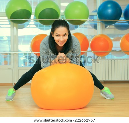 Young female with fit ball in sport center