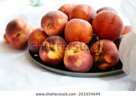 Summer tasty peaches on a plate with white background