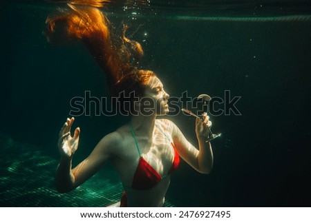 Similar – Foto Bild Unterwasser- Körperportrait mit Reflexion an der Wasserlinie von einer jungen Frau die der Kamera entgegen schwimmt