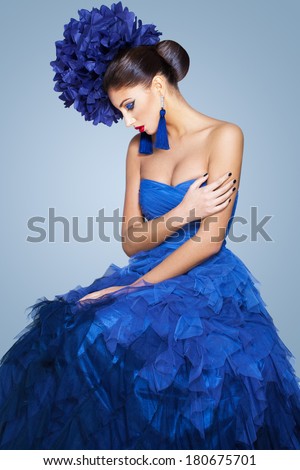 Beautiful model in a blue dress over neutral background