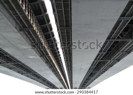 Underneath view and detail of a metal road bridge and sunlight