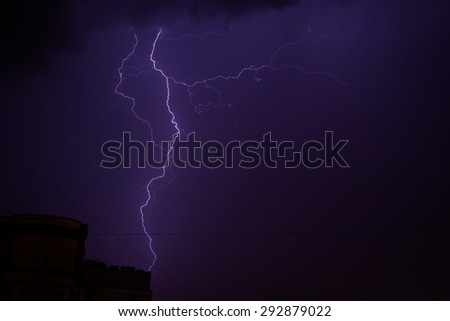 Bright electric blue lightning strike at night with dark storm sky