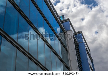 Clean modern style office building with reflected blue sky in the windows
