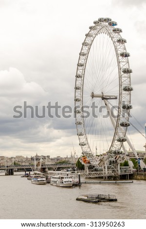 LONDON - ENGLAND 18TH AUGUST 2015 - Boats sail on the River Thames past the London Eye during a cloudy summer\'s day in August in London 2015