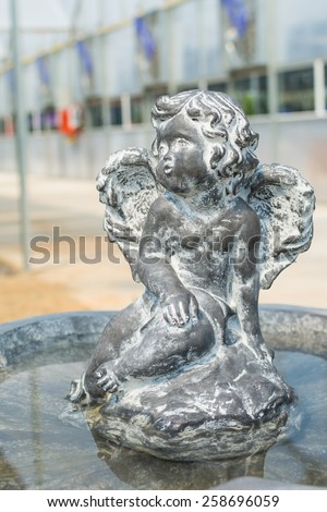 Statue of a cupid with fountain in the garden.