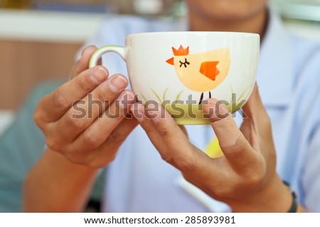 Cup of coffee in hand at the cafe