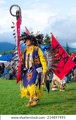 WEST VANCOUVER, BC, CANADA - AUGUST 30 : Unidentified Native Indian man with a flag takes part at the Squamish Nation 27th annual Pow Wow Grand Entry in West Vancouver, Canada on August 30 2014