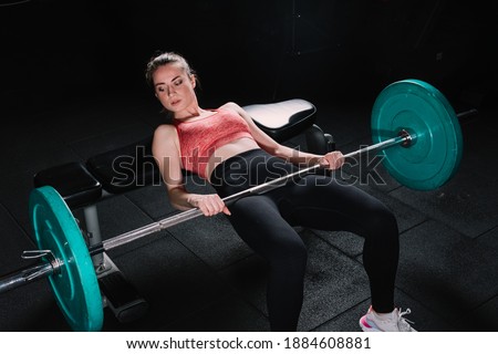 Young beautiful woman doing hip thrust. She poses with barbells in the gym. Сток-фото © 