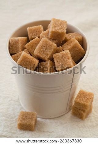 Brown sugar cubes in a white small metal bucket