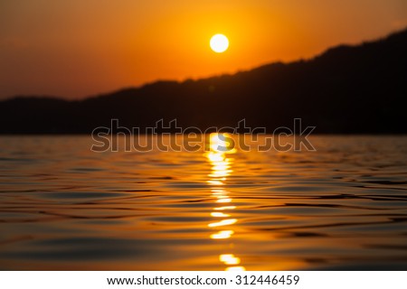 Blurred sunset at sea level, calm sea