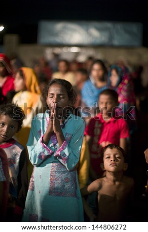 LAHORE, PAKISTAN- AUG 2 2012: Unidentified children in a slum prayed for better future of the community on August 2 2012 in Lahore, Pakistan. Children in Pakistan suffer from poor education.