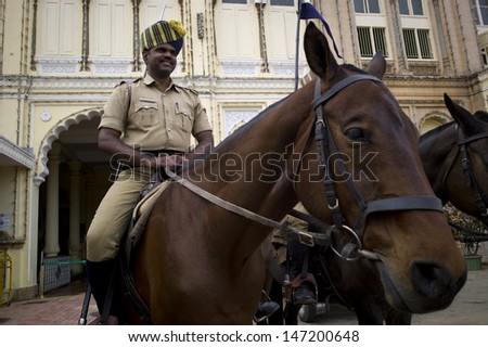 MYSORE, INDIA - AUG 11: A mounted police is patrolling in front of Mysore Palace in Mysore, India, on August11, 2011. Mysore palace is one of the most famous tourist attractions in India.