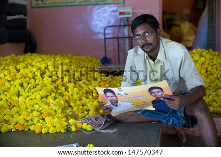 MADURAI, INDIA - AUG 12: Unidentified man sell flowers in flower market on August 12, 2012 in Madurai, India. In India poor grassroots often sell flowers to earn a small cash income.