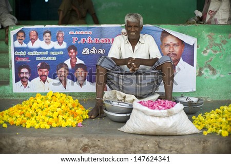 MADURAI, INDIA - AUG 12: Unidentified Indian man sell flowers in flower market on August 12, 2012 in Madurai, India. In India poor grassroots often sell flowers to earn a small cash income.