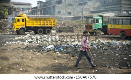 MUMBAI, INDIA - NOV 13: Unidentified child is playing cricket next to a garbage disposal area in a slum on November 13, 2012 in Mumbai, India. Over 60% of population lives in slums in Mumbai.