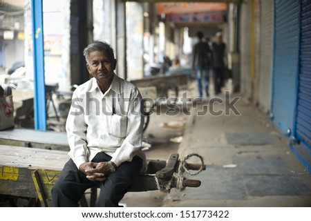 DELHI, INDIA - NOV 18: Unidentified old man chills out in a classical street in Old Delhi. November 18, 2012 in Delhi, India. The lifestyle in old delhi is still well kept like that in 100 years ago.