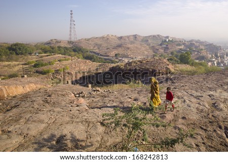 JODHPUR, INDIA - FEB 1: Indian woman and child are walking through the desert in Jodhpur, India on February 1 2013. Jodhpur is located in Thar Desert which is one of the largest desert in Asia.