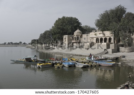 JAISALMER, INDIA - JAN 22: boats docked at the pier by Gadsisar Lake on January  22, 2013 in Jaisalmer, India.Gad sisar Lake is a manmade reservoir that was built in 1400.