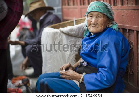 DALI, CHINA - MAY 15: An old woman is selling tea in the flea market on the street in Dali, China on May 15 2014. Yunnan is famous for tea.