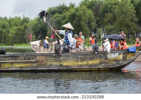 DALI, CHINA - MAY 16: People fishing on Erhai lake near Dali, Yunnan province, China on May 16 2014. Fishermen are Bai, a minority ethnic, and they use birds to fish.