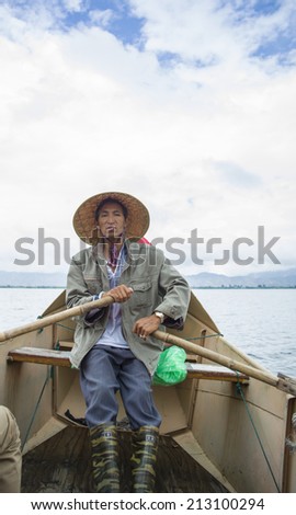 DALI, CHINA - MAY 16: man fishing on Erhai lake near Dali, Yunnan province, China on May 16 2014. Fishermen are Bai, a minority ethnic, and they use birds to fish.