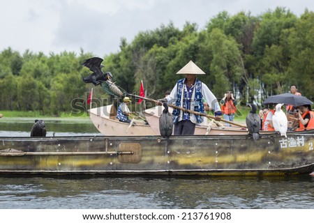 DALI, CHINA - MAY 16: People fishing on Erhai lake near Dali, Yunnan province, China on May 16 2014. Fishermen are Bai, a minority ethnic, and they use birds to fish.