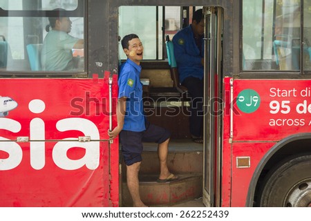 YANGON, MYANMAR, MAR 6: The conductor on the city bus in Yangon, Myanmar on March 6 2015. It is the major transportation in the city.