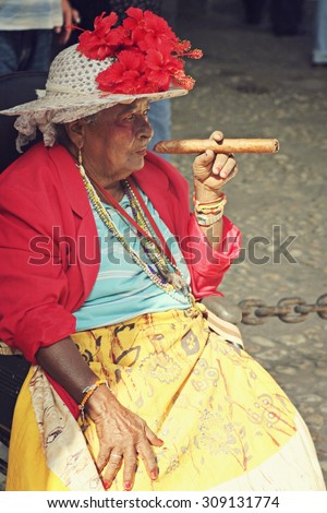 HAVANA, CUBA - FEB 16: An old lady is smoking a big cigar on the street in Havana, Cuba on February 16 2008.