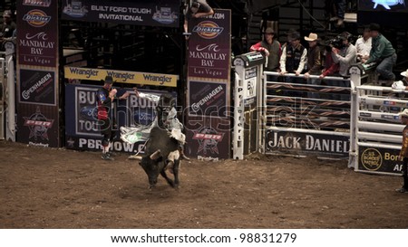 NEW YORK - JAN 10: A bull rider tried to stay on the bull for 8 seconds during the Professional Bull Rider tournament on January 10, 2009 in New York, NY.