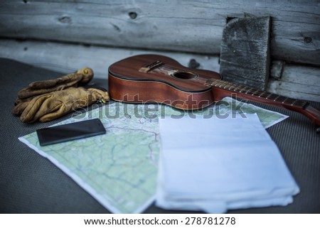 tourist still life - guitar, map, gloves, phone on old wooden background