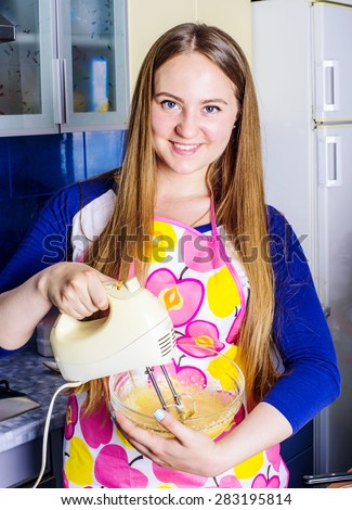 young caucasian female cooking  pie on a kitchen