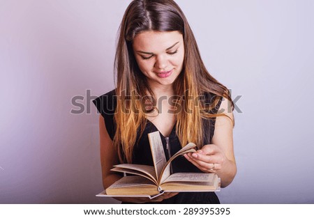 young caucasian female with books on grey background, education concept