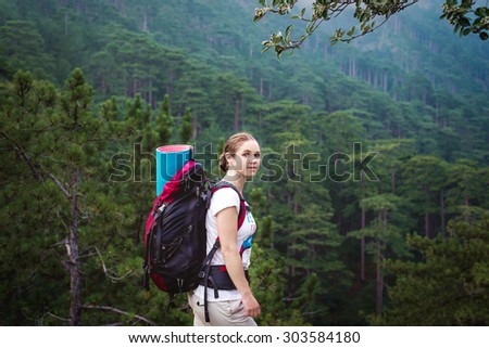 Caucasian hiker woman on trek in mountains with backpack living a healthy active lifestyle. Hiker girl on nature landscape hike in Crimea.