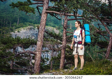 Caucasian hiker woman on trek in mountains with backpack living a healthy active lifestyle. Hiker girl on nature landscape hike in Crimea.