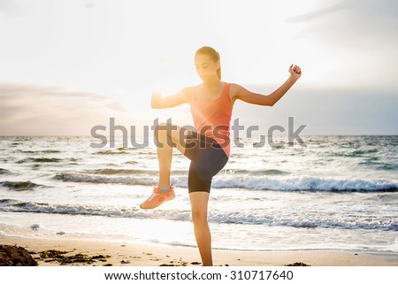 Fitness sport model smiling happy doing exercises during outdoor work out on sunrise. Beautiful caucasian female training outside on seaside in the morning