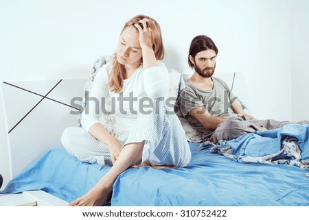 young caucasian couple in bed discussing their problems