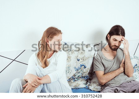 young caucasian couple in bed discussing their problems